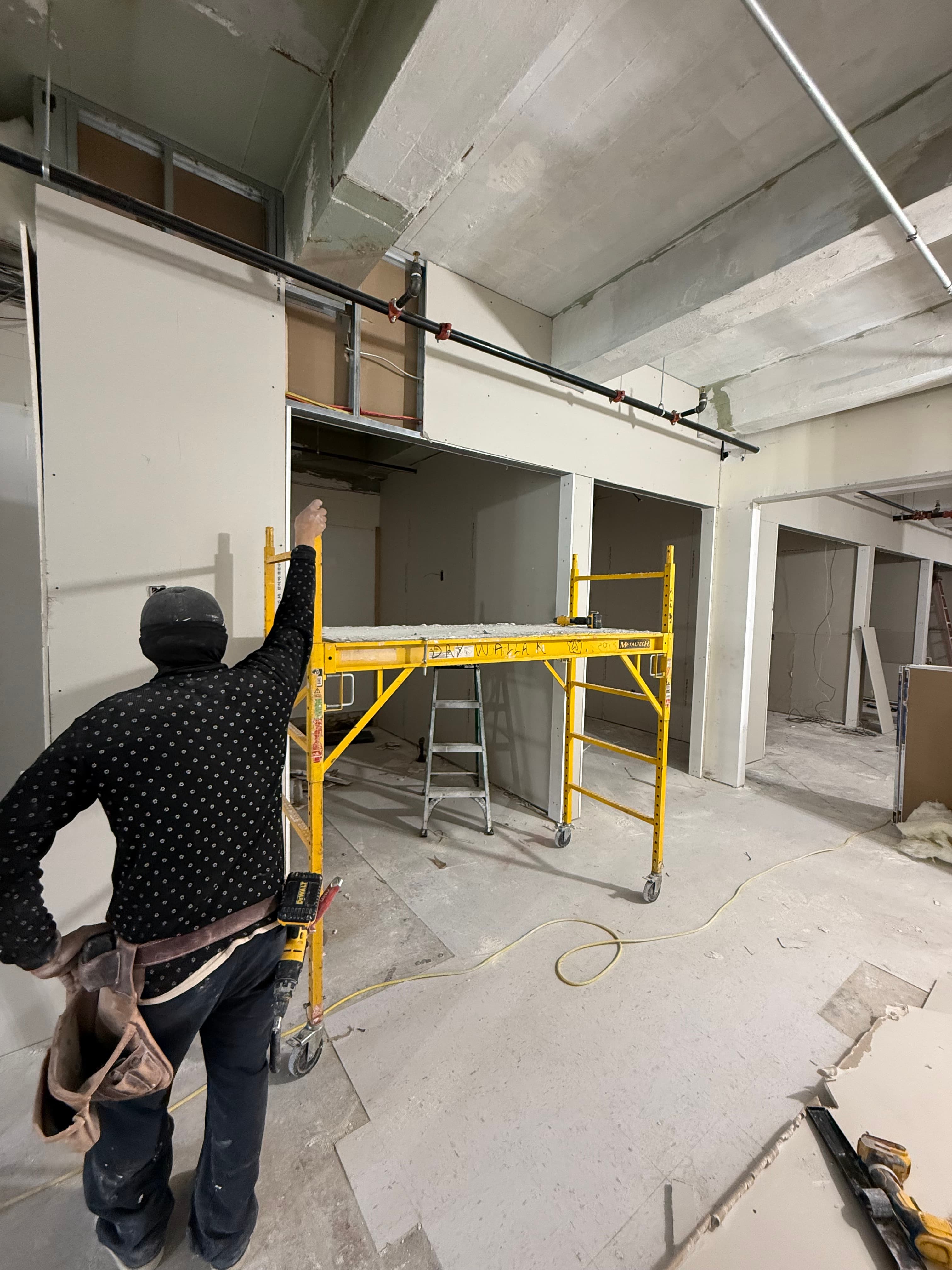 Worker pointing at soffit near scaffold